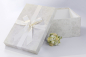 Preview: Die BrautkleidboxSilver Flowers wird mit einer passenden weißen Satinschleife komplettiert.
